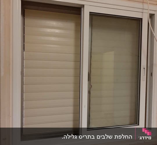 חלון עם תריסים סגורים בצבע לבן